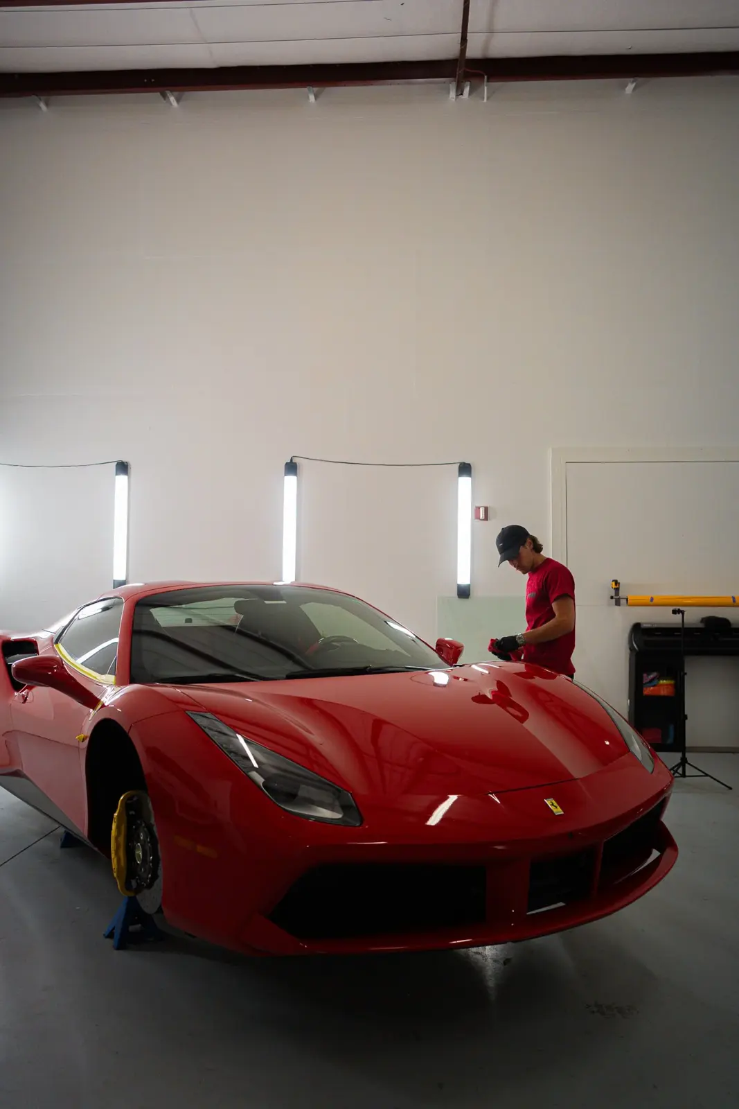 Red Ferrari in the studio with a technician working behind it