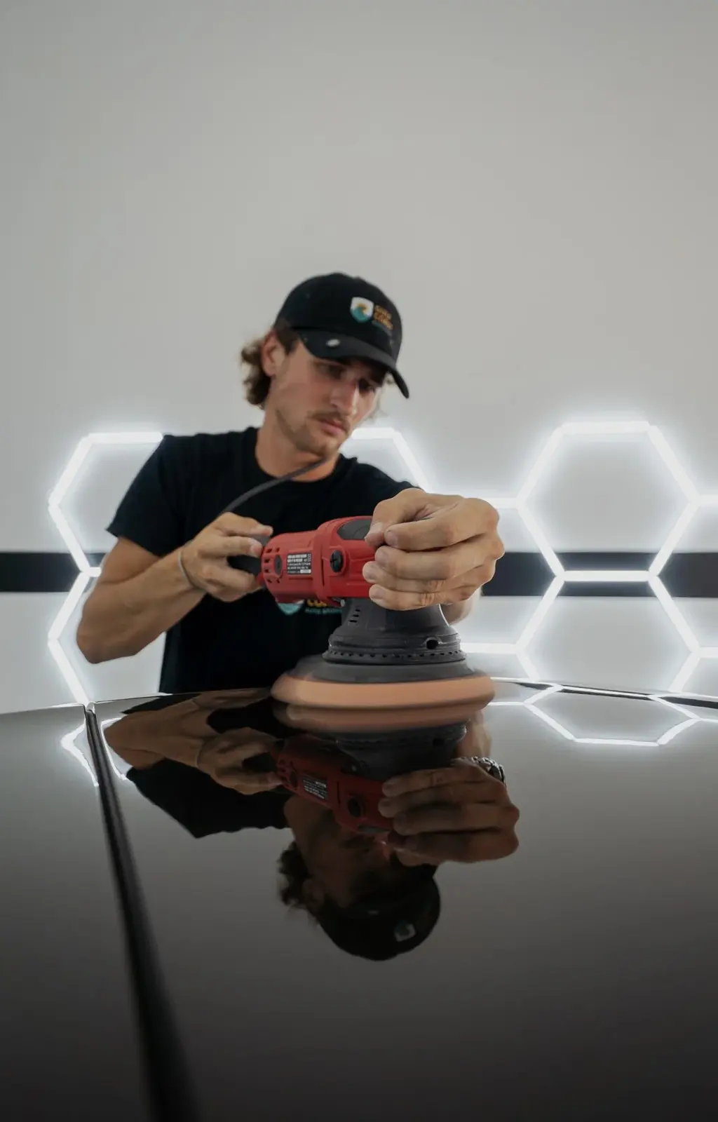 Detailer machine-polishing a car’s paint