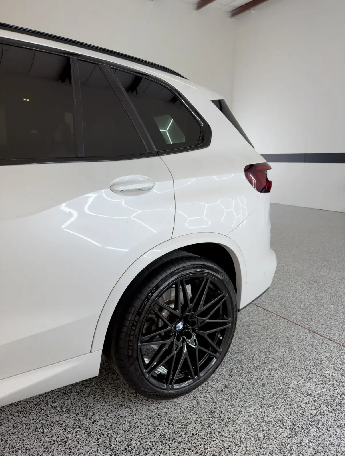 White SUV with dark rear window tint in the Gulf Coast Auto Studio bay