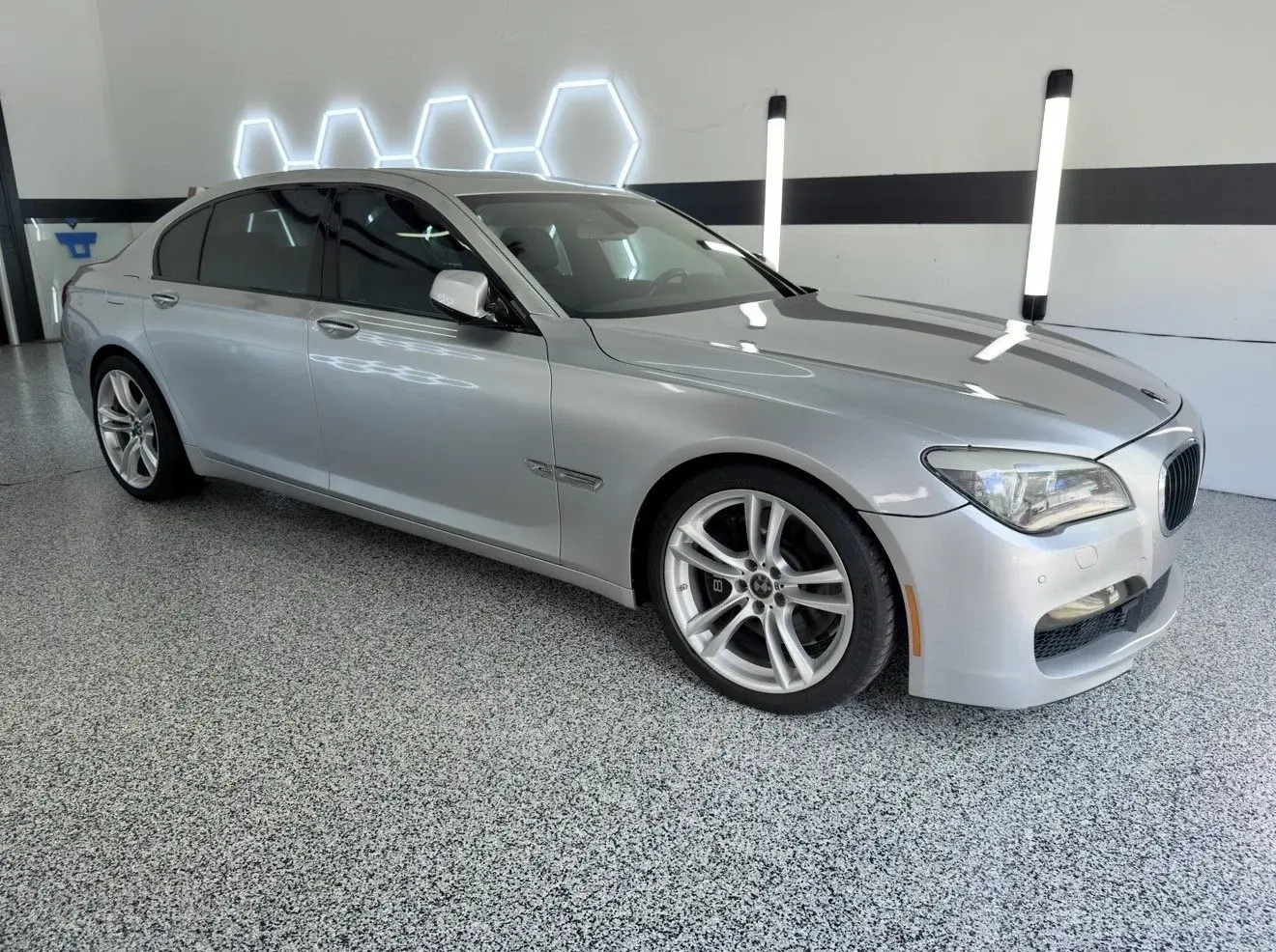 Silver BMW 7 Series sedan in the Gulf Coast Auto Studio bay