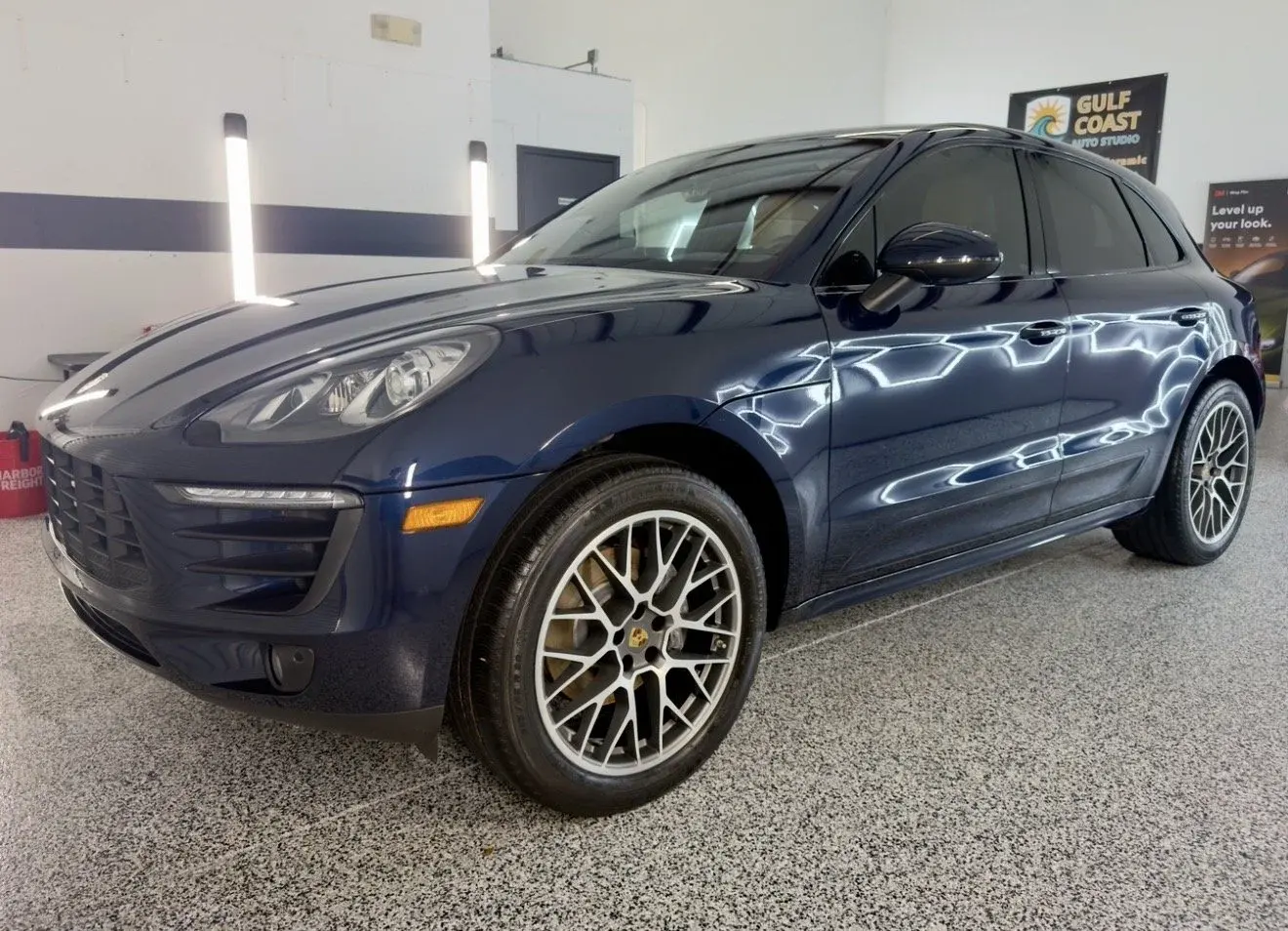 Blue Porsche Macan with glossy paint in the Gulf Coast Auto Studio bay
