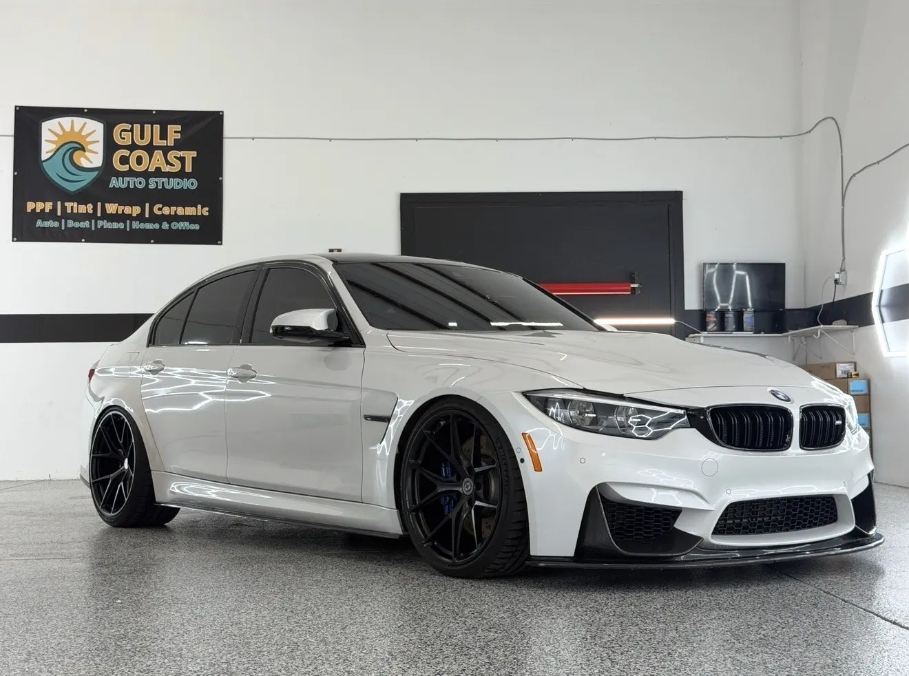 White BMW M3 sedan in the Gulf Coast Auto Studio bay in Sarasota