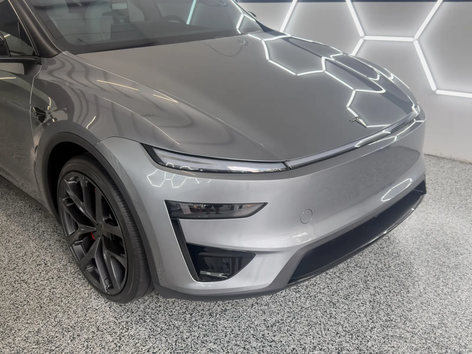 Silver Tesla Model Y with paint protection film in the Gulf Coast Auto Studio bay