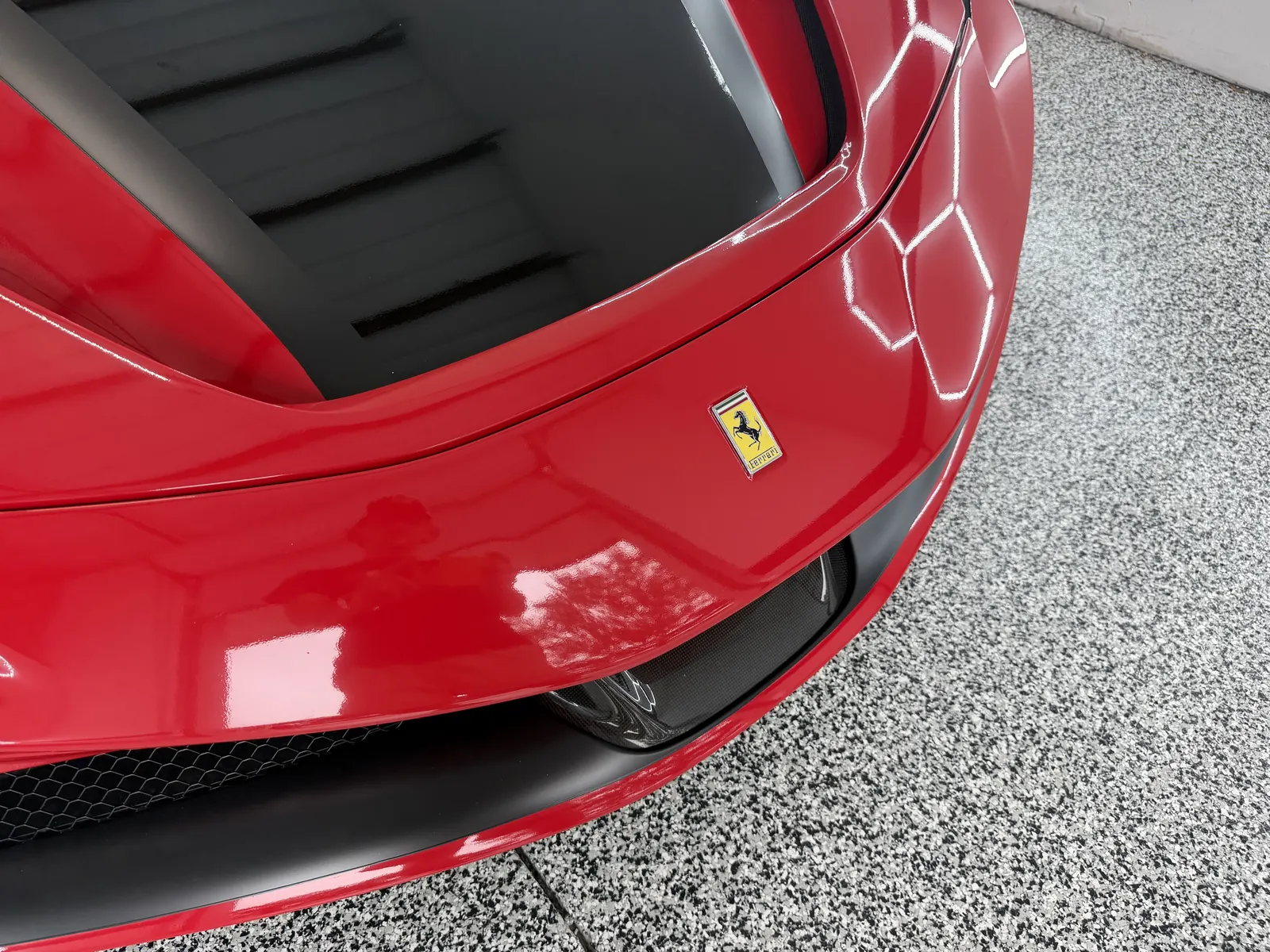 Front of a red Ferrari with vinyl wrap in the Gulf Coast Auto Studio bay