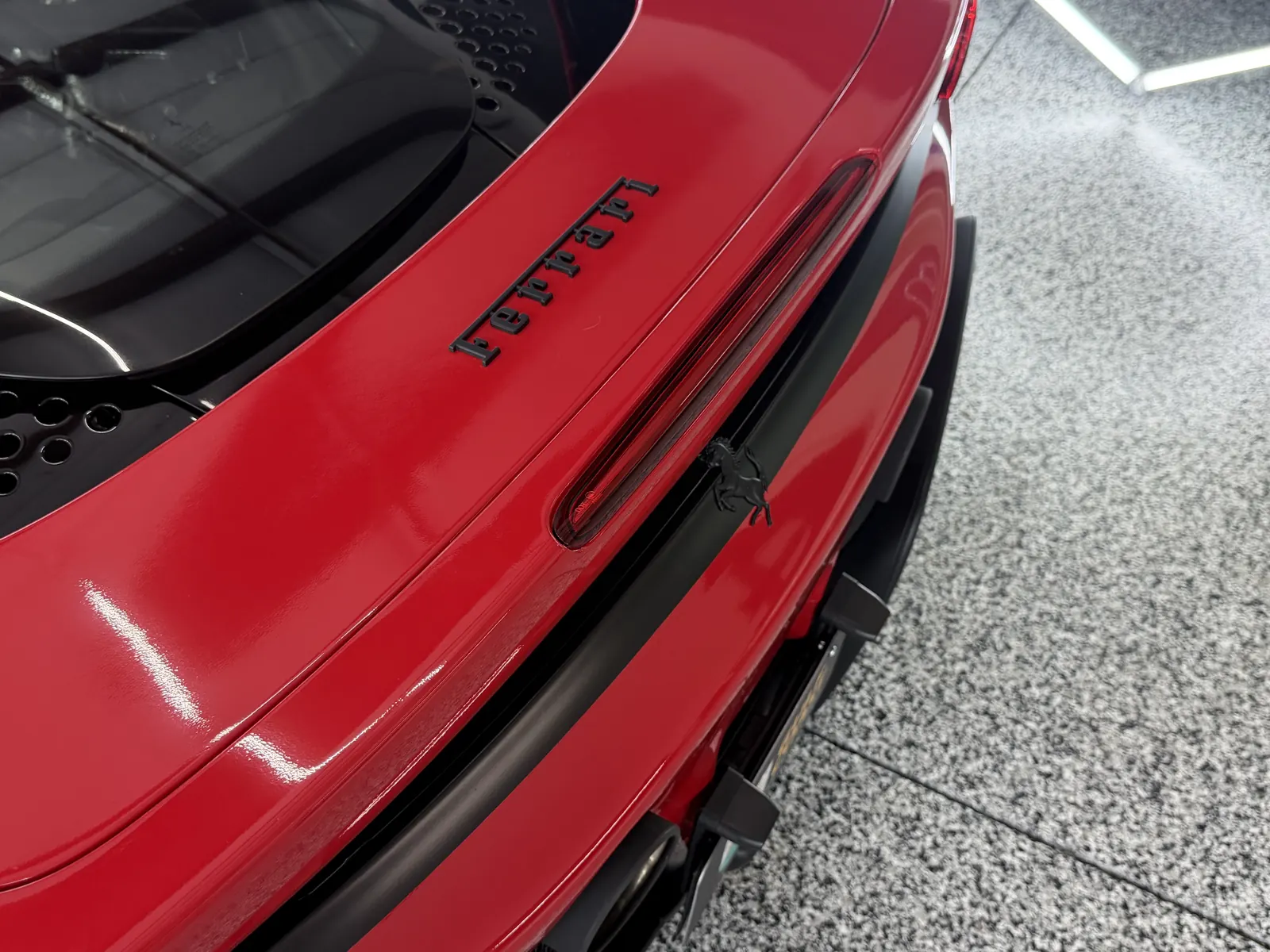 Rear of a red Ferrari with blacked-out emblems